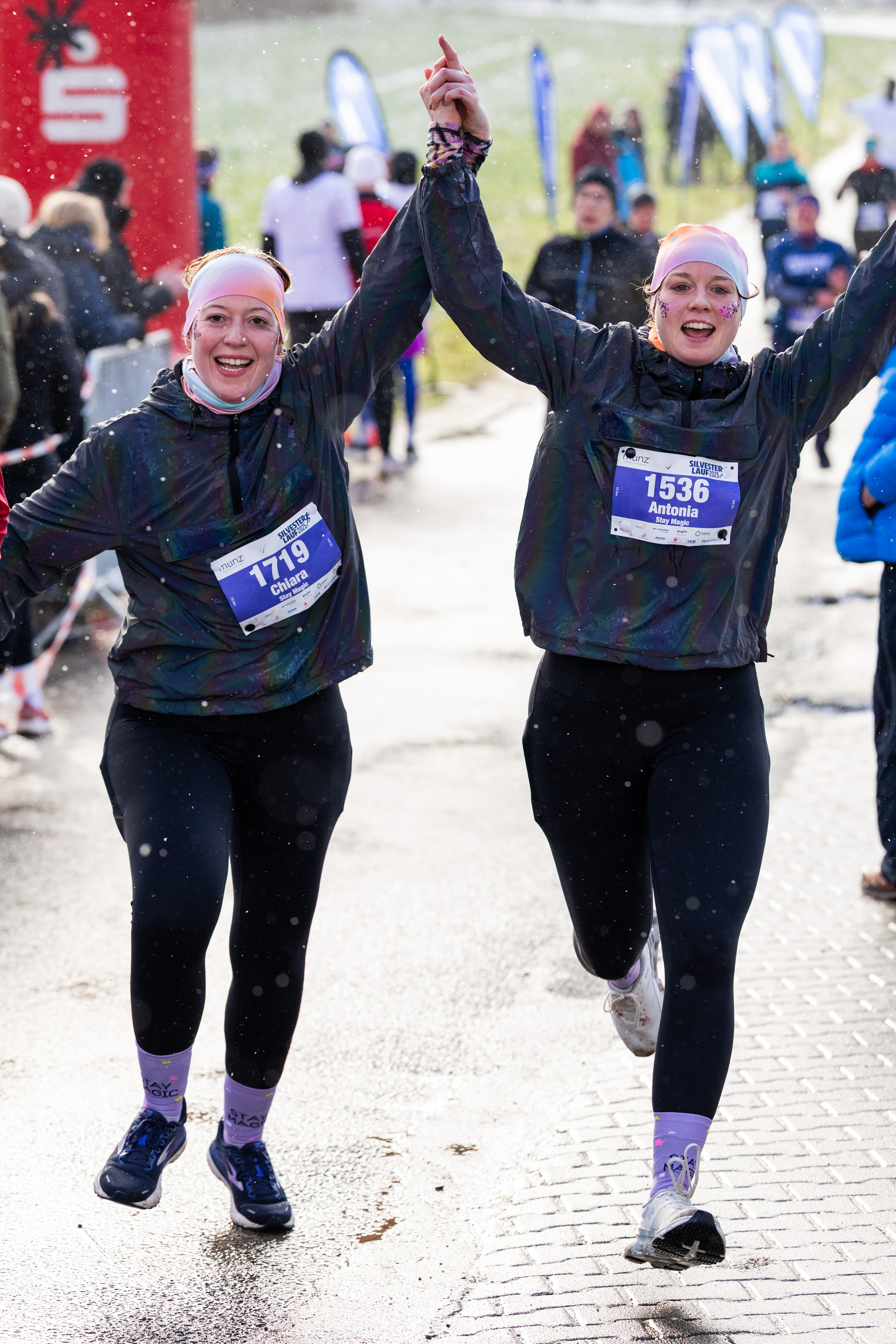 Zwei Läufer jubeln Hand in Hand beim Zieleinlauf